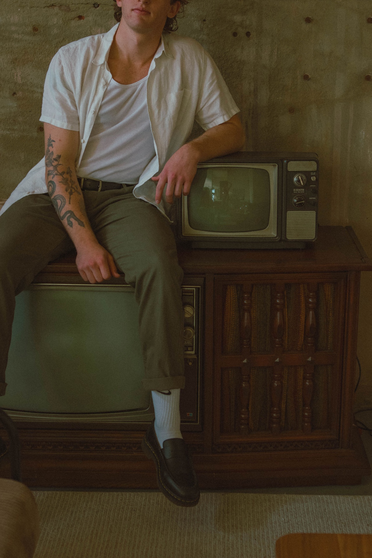 Portrait of Isaiah Waters seated on a vintage television console